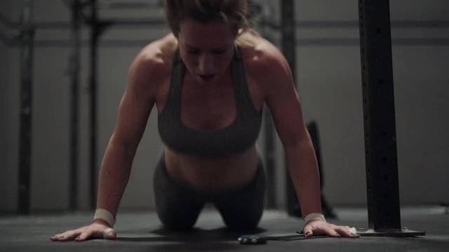 Female Athlete Performing Burpees And Press Ups