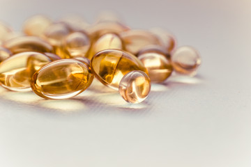 Cod liver oil capsules in a fish shape with copy space. Healthcare concept