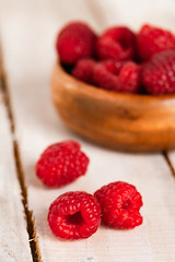 Ripe red raspberry on rustic wooden background. Healthy dessert, summer mood. Macro, close up, front view, copy space