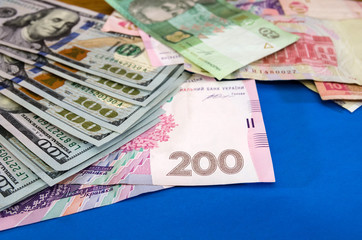 different hryvnias and dollars on a blue background. Business concept.