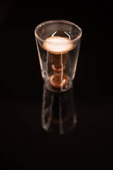 Irish coffee served into a stylish glass on a black reflective table