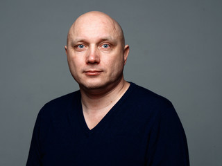 Obraz premium Portret łysy wesoły mężczyzna na szarym tle