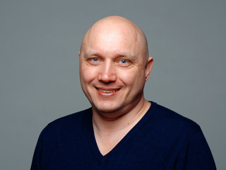 Obraz premium Portret łysy wesoły mężczyzna na szarym tle