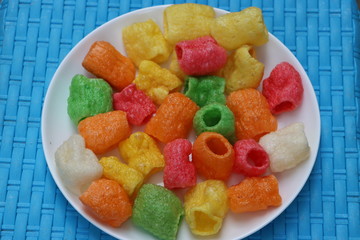 Colorful pipe fryums in a white plate, Indian fried snack 