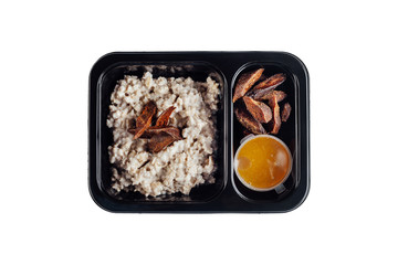 Healthy lunch at workplace. Take away meals in black containers with cutlery on gray table