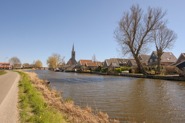 View of a church tower in a village on a canal