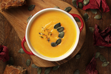 Pumpkin soup  with cream, sweet potato, carrot, pumpkins seeds and thyme leaves