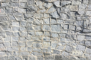 Old gray wall with masonry lit by the sun