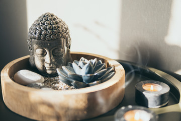 Meditation still life with Buddha statue, candle lights smoke and lotus flower