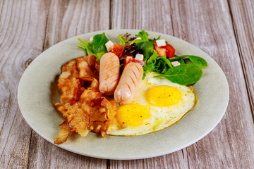 Franks, fried eggs, bacon and salad for breakfast.