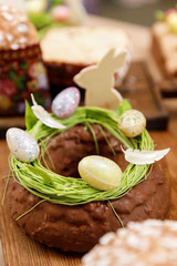 Easter cake orthodox sweet bread kulich and colorful chocolate eggs on festive table