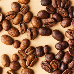 Coffee beans of different varieties close-up on a light brown background. For screensavers, roasters, coffee sellers. 