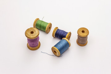 Colorful wooden spools of thread isolated on white background. Tool for sewing, handmade, craft, profession. Needlework, DIY