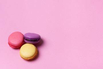 Obraz na płótnie Canvas Fresh tasty macaron cake or macaroon on pink pastel background top view. 