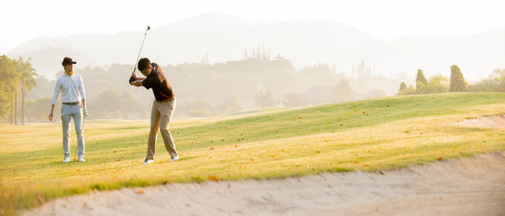 Asian man golfer playing golf with friend  at golf course