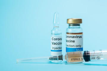 A test vaccine for coronavirus. A vial with a Vaccine from Covid-2019 on a blue background. A cure for the virus. Pandemic 2020. Experimental medicine.