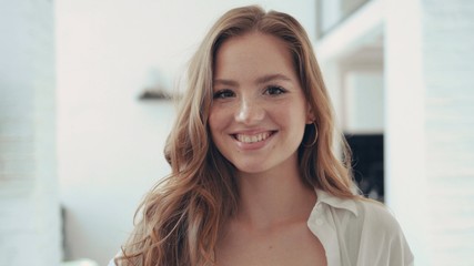 Portrait of the attractive young woman standing in front of the camera smile at home indoors charming attractive female girl happy modern portrait close up