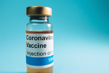 A test vaccine for coronavirus. A vial with a Vaccine from Covid-2019 on a blue background. A cure for the virus. Pandemic 2020. Experimental medicine.