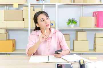 Shipping shopping online ,young start up small business owner writing address on cardboard box at workplace.small business entrepreneur SME or freelance asian woman working with box at home