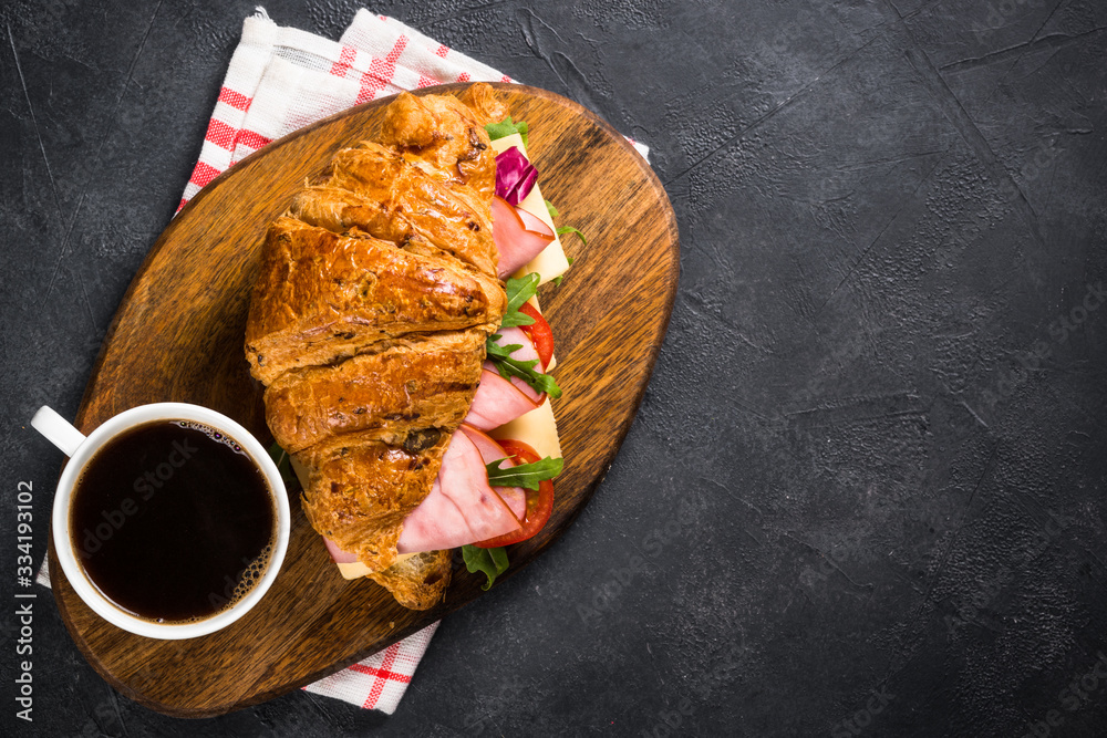 Canvas Prints Croissant sandwich on black table.