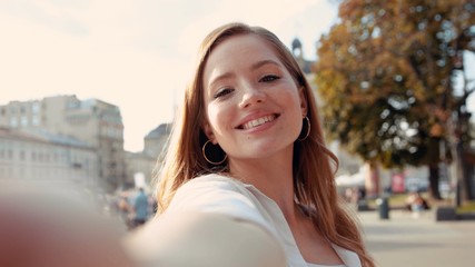 Happy smiling gorgeous young woman woman with curly hair look at camera poses take selfie portrait sunlight summer face sunset lady outdoor cute