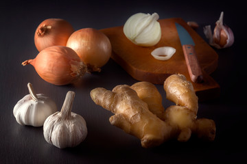 Ginger, garlic, onion - a vegetable mixture to increase immunity from viruses on a dark table. Low key.