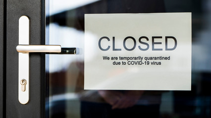 Business owner hangs on door announcement of closure due to coronavirus quarantine.