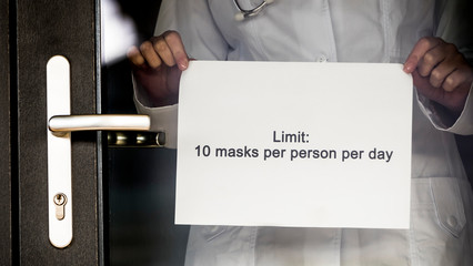 Announcement on the pharmacy door about the limit of sales of medical masks