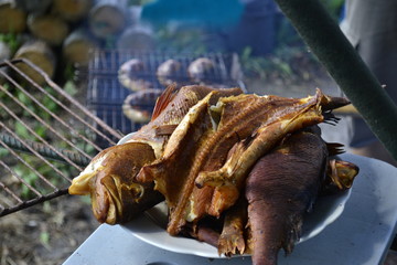 Smoked carp fish BBQ photo. Fish on the white plate, just cooked.