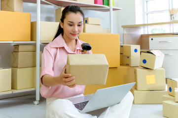 Portrait of beautiful Asian woman packing a parcel boxes close up. E-Commerce and online shopping concept.