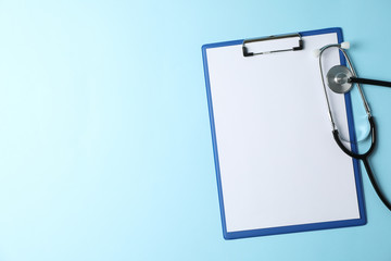Tablet and stethoscope on blue background, top view and space for text