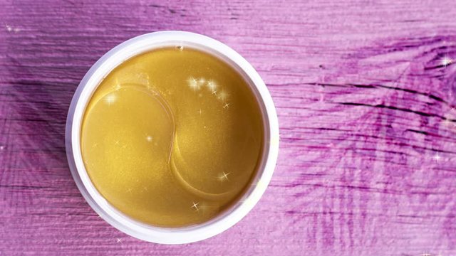 Gold face patches on a pink wooden background. The shadow of the palm branches.