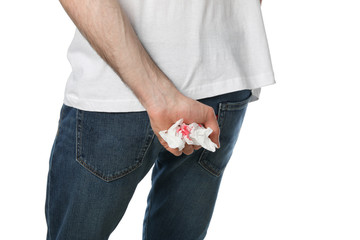 Man holds toilet paper with blood, isolated on white background
