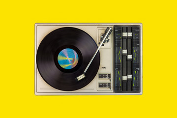 Vintage turntable with spinning record on a yellow background