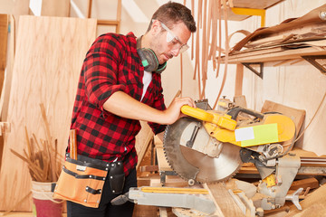 Man as carpenter Trainee at the chop saw