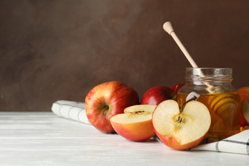 Apples and honey against brown background, space for text