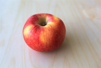 Isolated fresh whole boskoop red apple for healthy diet on wood table in natural daylight