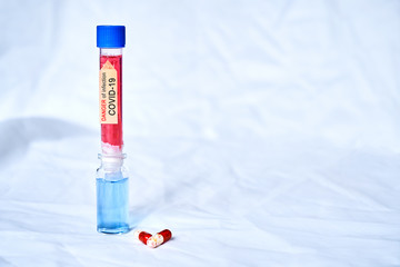 Flasks with red and blue liquid and KOVID-19 coronavirus on a white background