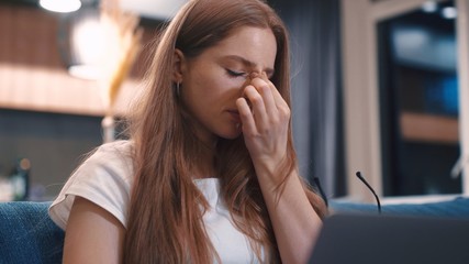 Obraz premium Feeling tired and stressed frustrated young redhair woman keeping eyes closed at home young businesswoman is tired feels stressed out Close up slow motion freelancer internet job study online
