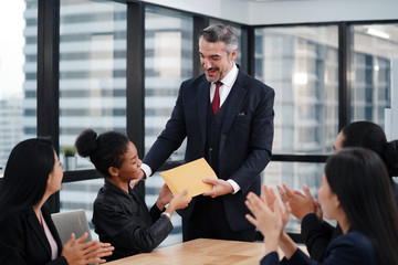 Happy CEO and business team congratulating successful African American worker by clapping hands, smiling black employee excited by reward bonus promotion.        