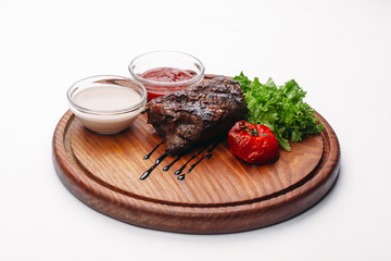 steak with red and white sauce and herbs on a tree