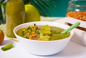 Fresh blended green smoothie bowl with muesli and chia seeds. Health and detox concept.
