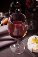 glass of red wine and plate with assorted cheese, fruit and other snacks for party