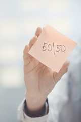Fifty-fifty text on adhesive note