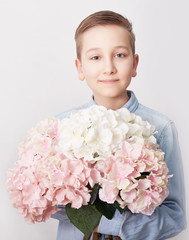 Child boy with bouquet of flowers. Mother's Day Greeting Card. Happy mothers day frame background. Spring card template. Happy Birthday or Valentine. Women's Day. Copy space. Child gives bouquet