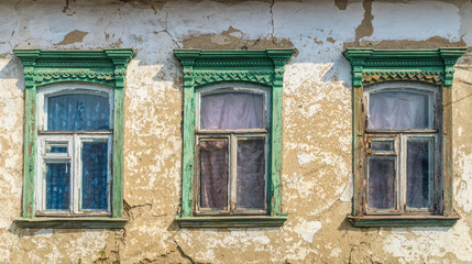 Old wooden windows of an ancient rustic adobe house
