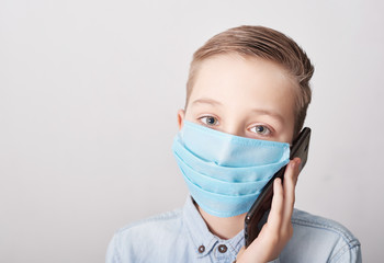 Child in medical mask with mobile phone. Coronavirus and Air pollution pm2.5 concept. Virus symptoms. Concept of epidemic, influenza, protection from disease, vaccination. Flu illness. Medical care.
