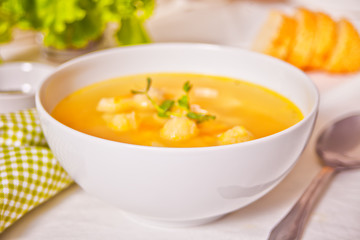 Pea soup in a white bowl with herbs.