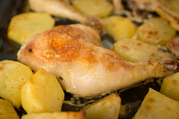 Appetizing fried chicken meat with fried potatoes close-up. Shallow depth of field, some objects out of focus