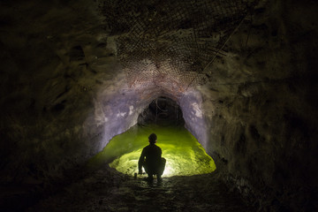 Underground gold mine tunnel settler pond with miner explorer
